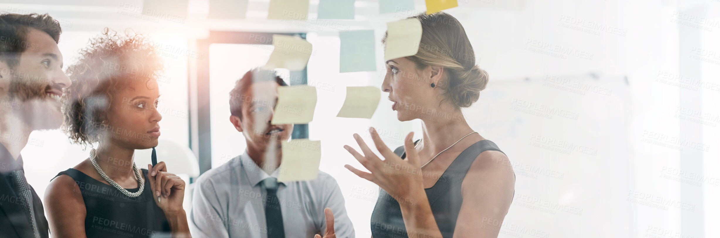 Buy stock photo Shot of coworkers using sticky notes against the wall during a brainstorming session