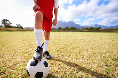 Buy stock photo Child, soccer ball and legs on green grass for sports, training or practice with clouds and blue sky. Closeup of football player with foot ready for kick off, game or match on outdoor field in nature