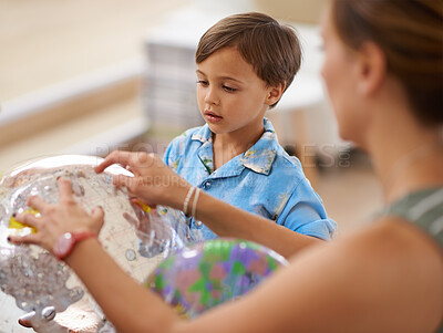 Buy stock photo A mother playing with her son and an inflatable world globe