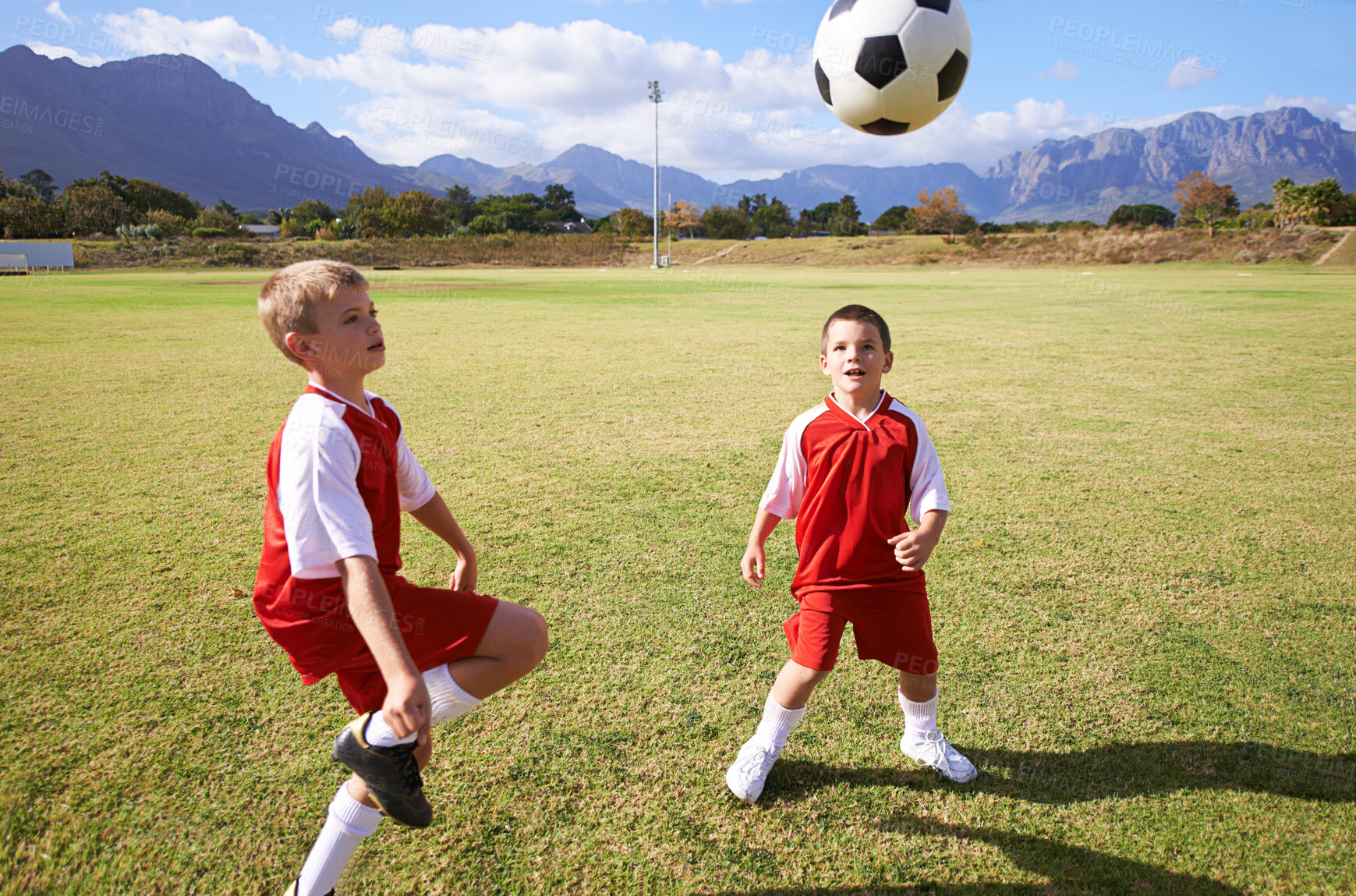 Buy stock photo Children, exercise and playing soccer on grass, practice and training for match and game in outdoors. People, kids and fitness or cardio and sports, ball and sportswear or workout together for fun