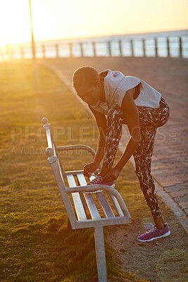 Buy stock photo Black woman, runner and tie shoes on park bench by sea with sunrise, sport and promenade workout. Exercise, morning and health with start, ocean and running fitness for wellness with athlete outdoor