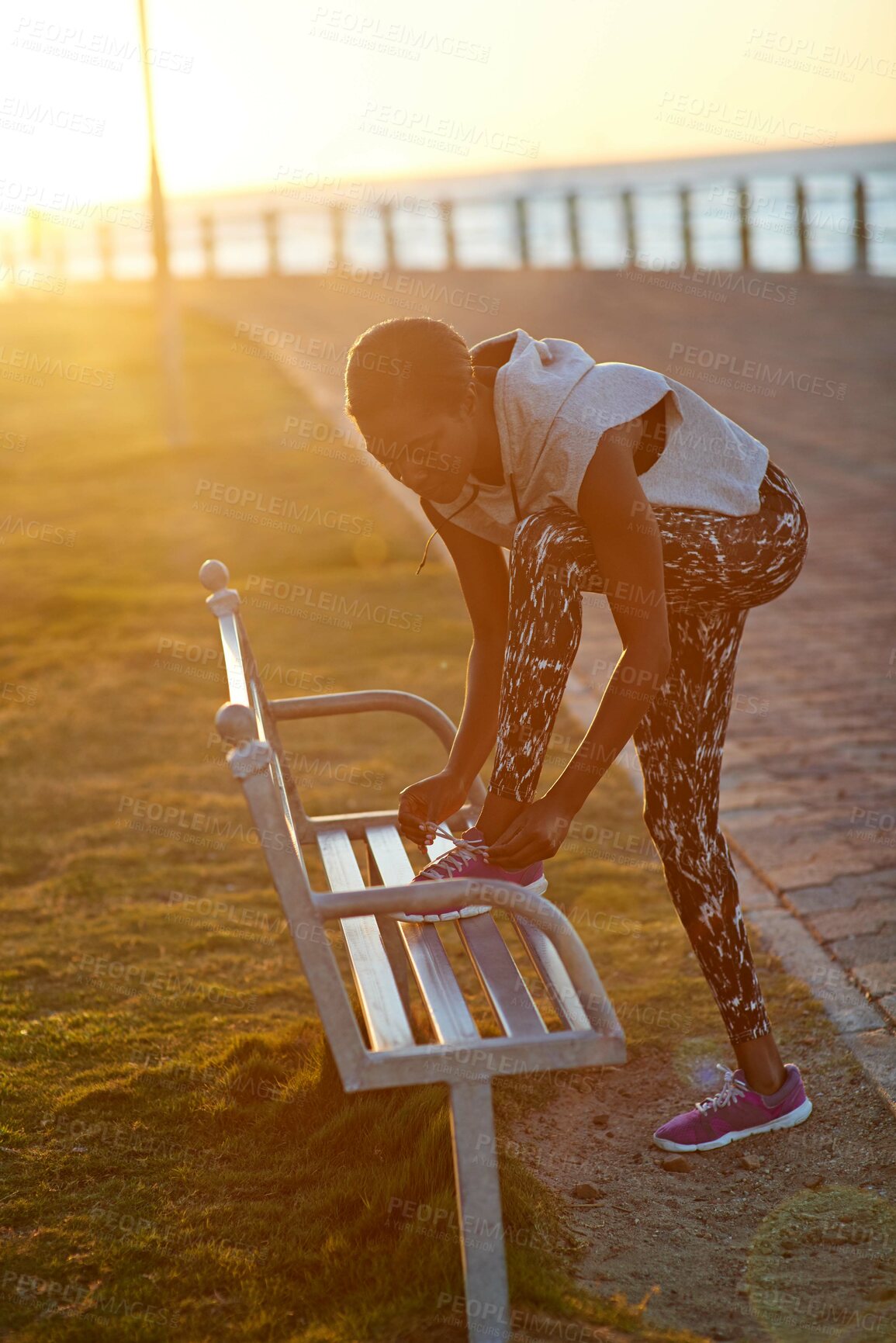 Buy stock photo Black woman, runner and tie shoes on park bench by sea with sunrise, sport and promenade workout. Exercise, morning and health with start, ocean and running fitness for wellness with athlete outdoor