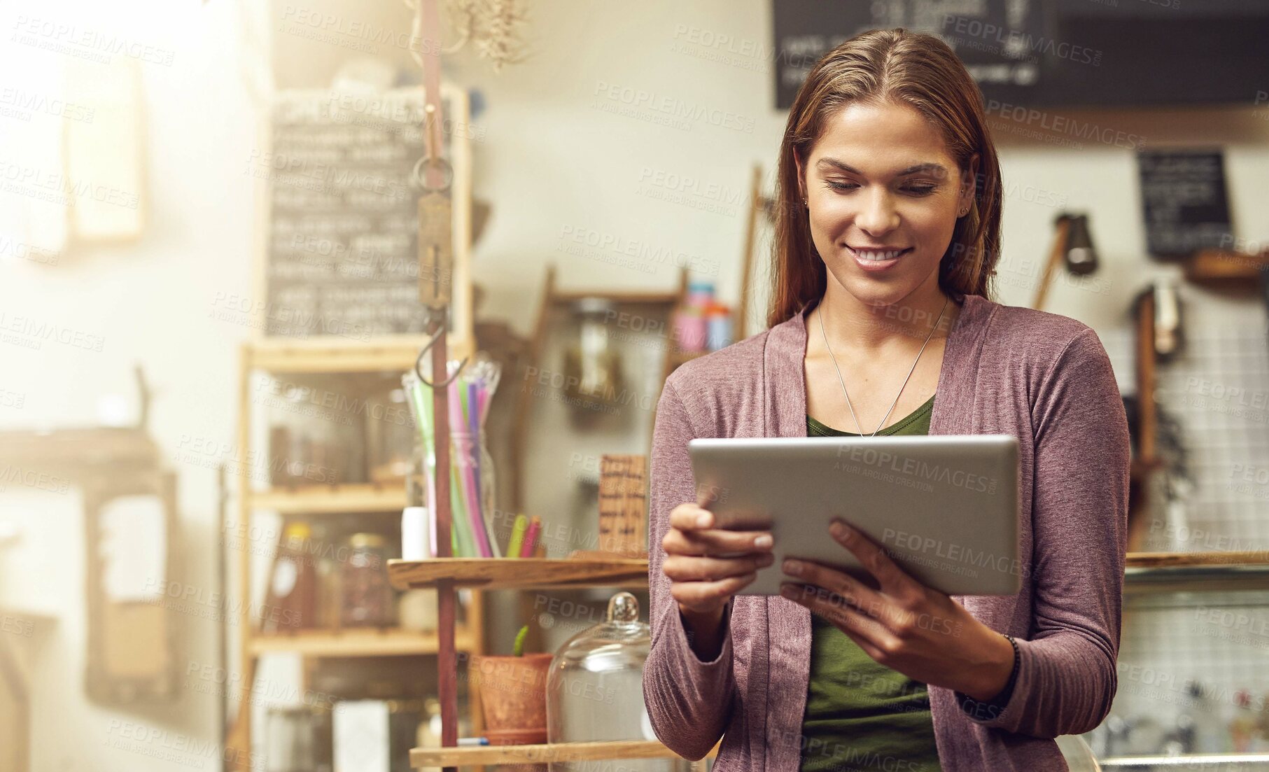 Buy stock photo Shot of a young entrepreneur using a digital tablet in her store