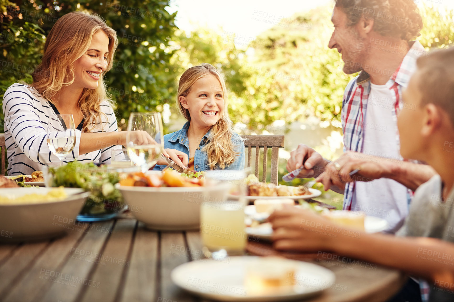 Buy stock photo Smile, parents and kids at outdoor lunch with fun, thanksgiving celebration and family eating in backyard. Mom, dad and children at table together for garden picnic with food, happy bonding and love