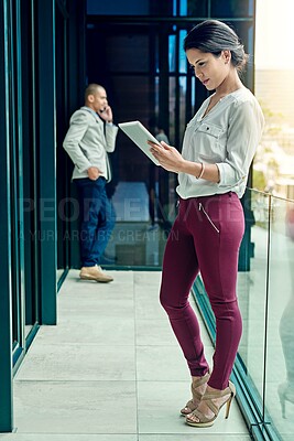 Buy stock photo Shot of a young businesswoman using a digital tablet at work