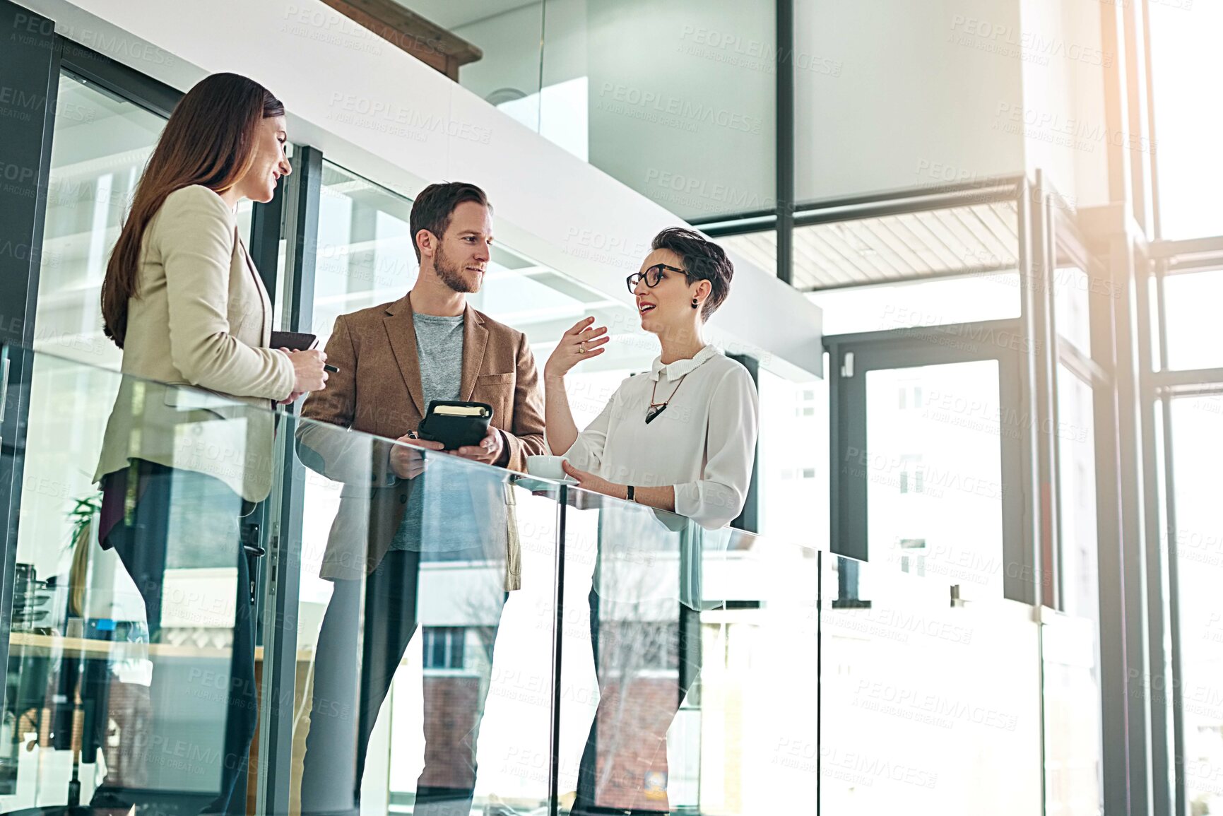 Buy stock photo Shot of a group of colleagues talking together in a large modern office