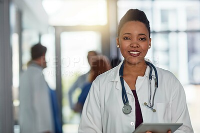 Buy stock photo Portrait of a young female doctor standing in a hospital with her colleagues in the background