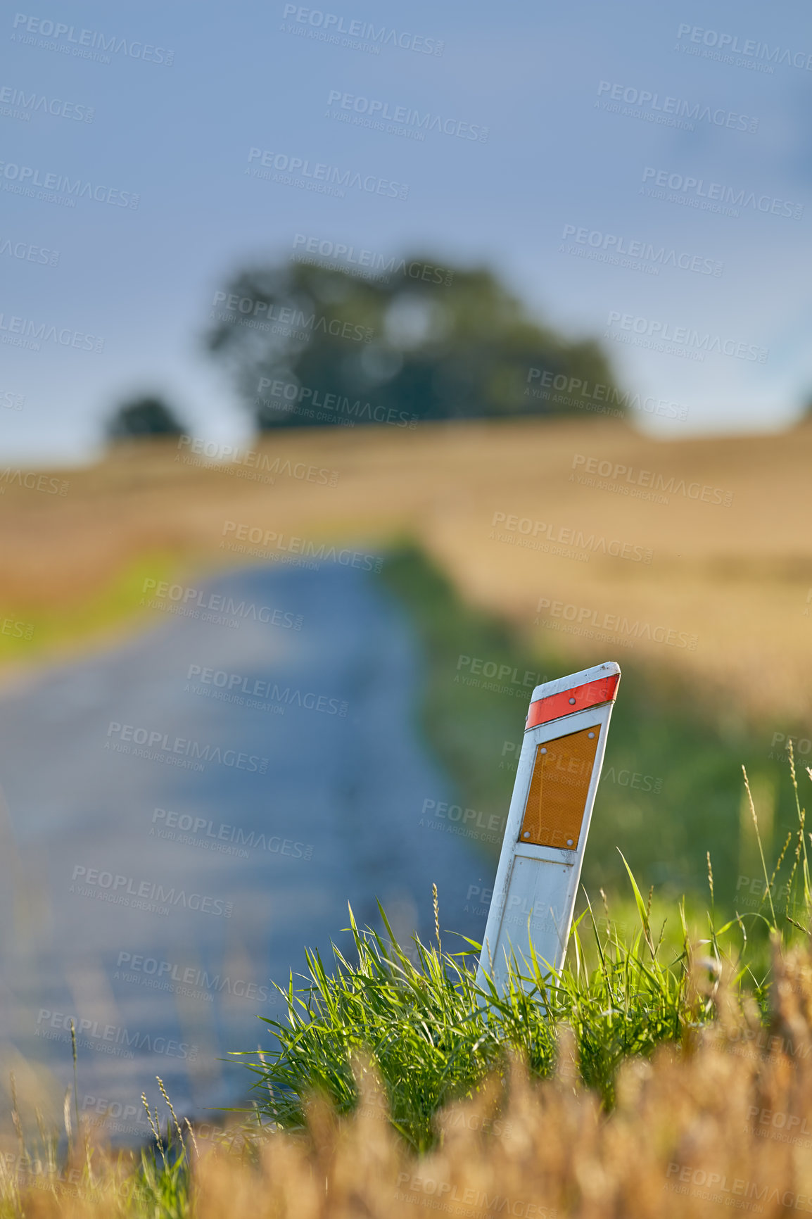 Buy stock photo Grass, mile marker and road with reflector, closeup and distance measure for transport or drive. Background, earth and travel with checkpoint in summer countryside for adventure or journey