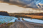 Nature, farm and cloudy with path for snow, destination and outdoor location for winter journey. Dirt road, sustainability and cold with ice field for plants, landscape and travel in Netherlands