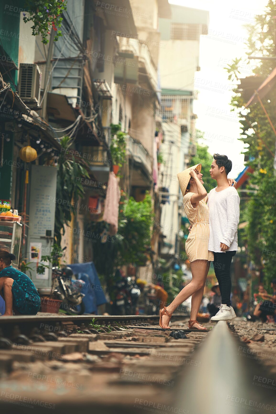 Buy stock photo Love, travel and couple in city for vacation, sightseeing and holiday for romance in relationship. Train track, happy and woman hug man for bonding together in urban town for weekend trip in Vietnam.