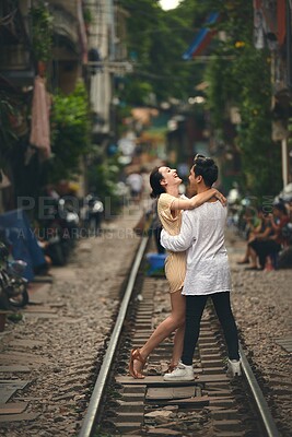 Buy stock photo Travel, dancing and couple on train tracks in Vietnam for holiday, vacation and tourist destination. Happy, love and man and woman laugh on railway for adventure, journey and bonding in urban city