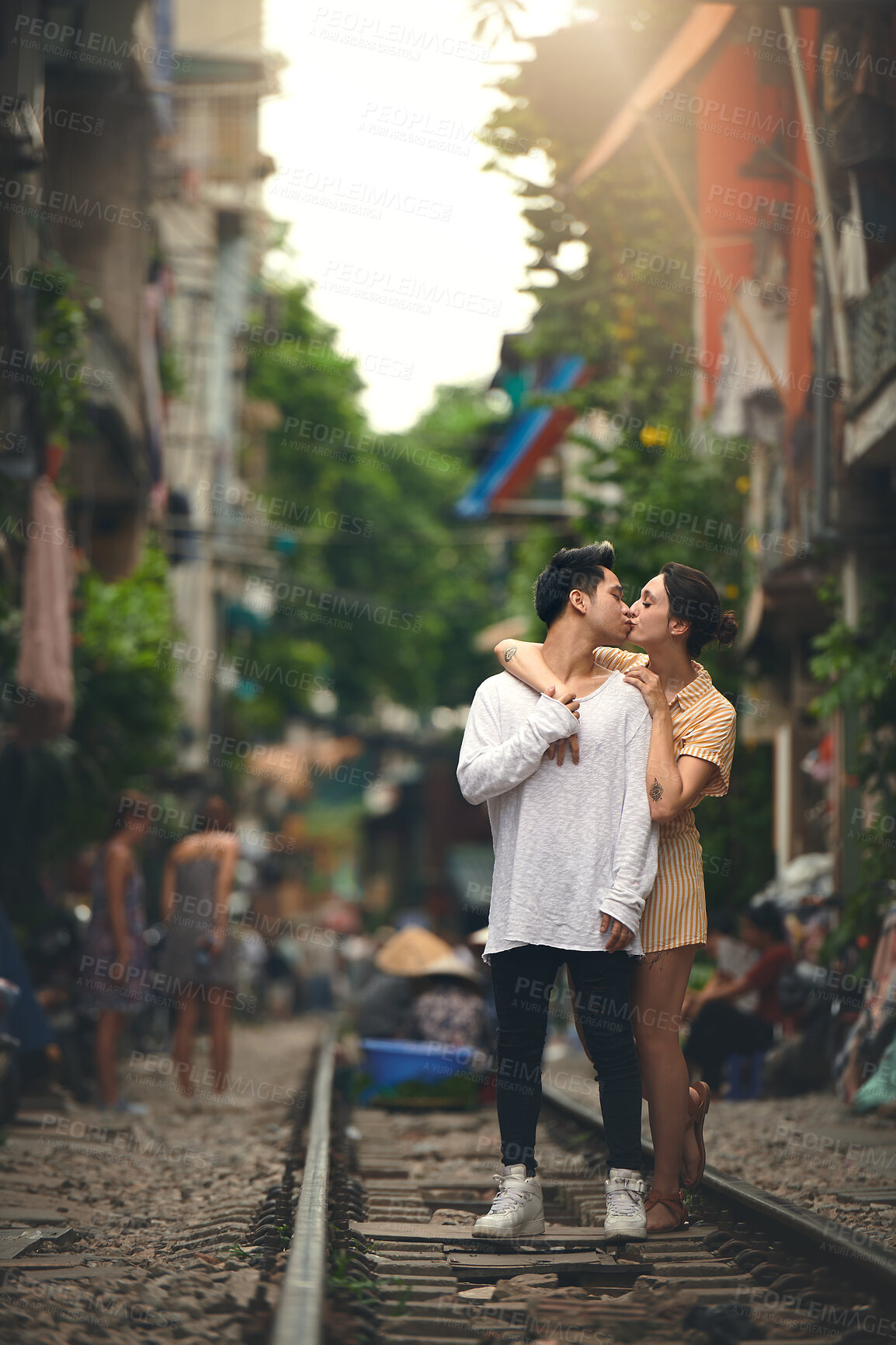 Buy stock photo Kiss, city and couple on railway in Vietnam for holiday, vacation and tourist destination. Embrace, love and man and woman on train tracks for adventure, journey and travel together for bonding