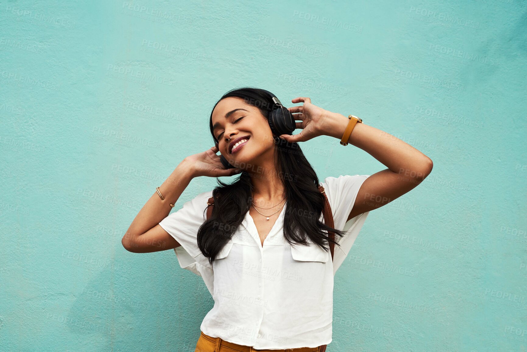 Buy stock photo Dance, music and energy with woman and headphones for streaming, freedom and sound. Fun audio, technology and celebration with person listening on blue background for confidence, crazy and positive