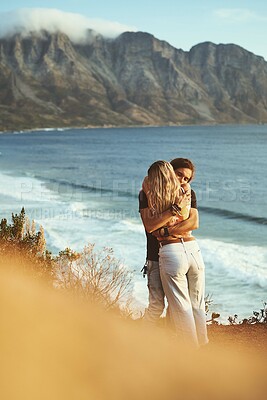 Buy stock photo Ocean, mountain and couple with hug on holiday, travel vacation and bonding together with embrace. Outdoor, man and woman with love for anniversary, connection and adventure with affection by flare