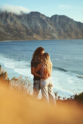 Buy stock photo Ocean, mountain and couple with kiss on holiday, travel vacation and bonding together with embrace. Outdoor, man and woman with hug for romantic anniversary, connection and adventure with affection