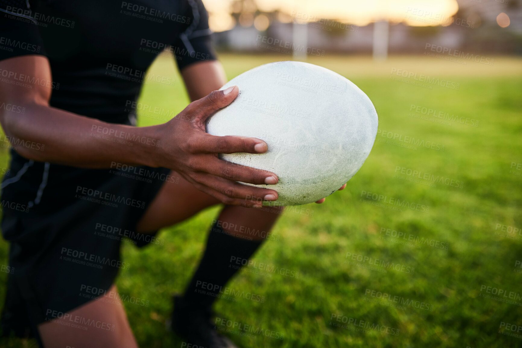 Buy stock photo Rugby, hands and man with ball for sports, game or competition at pitch. Player, oval and closeup of equipment at field for training match, exercise and athlete kneeling for fitness workout outdoor