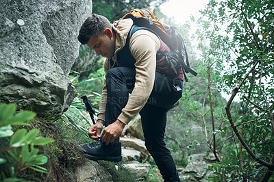 Buy stock photo Hiking, travel and tying laces with man in nature for explore, health and adventure. Challenge, wellness and holiday with person and shoes trekking on path for walking, fitness and camping vacation