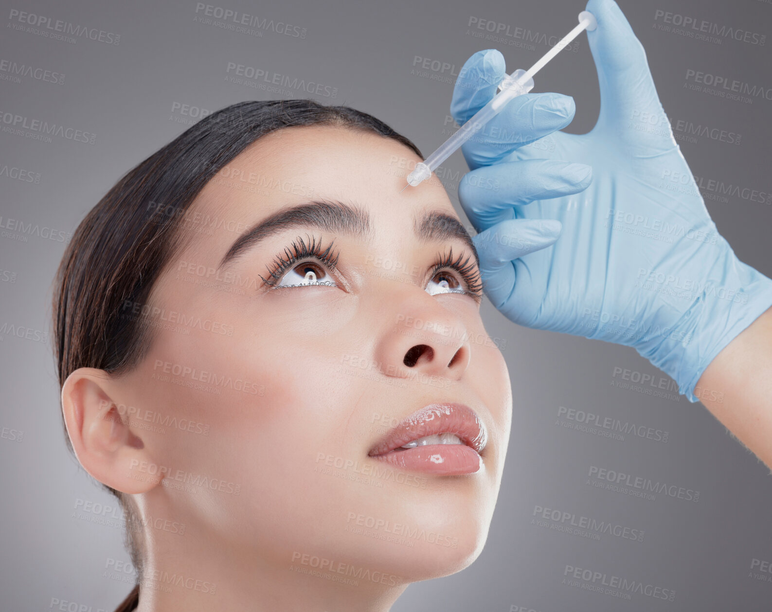 Buy stock photo Woman, hands and forehead injection in studio, skincare and cosmetic service on gray background. Female person, needle and plastic surgery or collagen treatment, syringe and implant or beauty filler