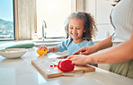 Mother and daughter cooking together. Little girl preparing food with her mother. Happy child helping her parent cook. Mother and daughter preparing a tasty meal.