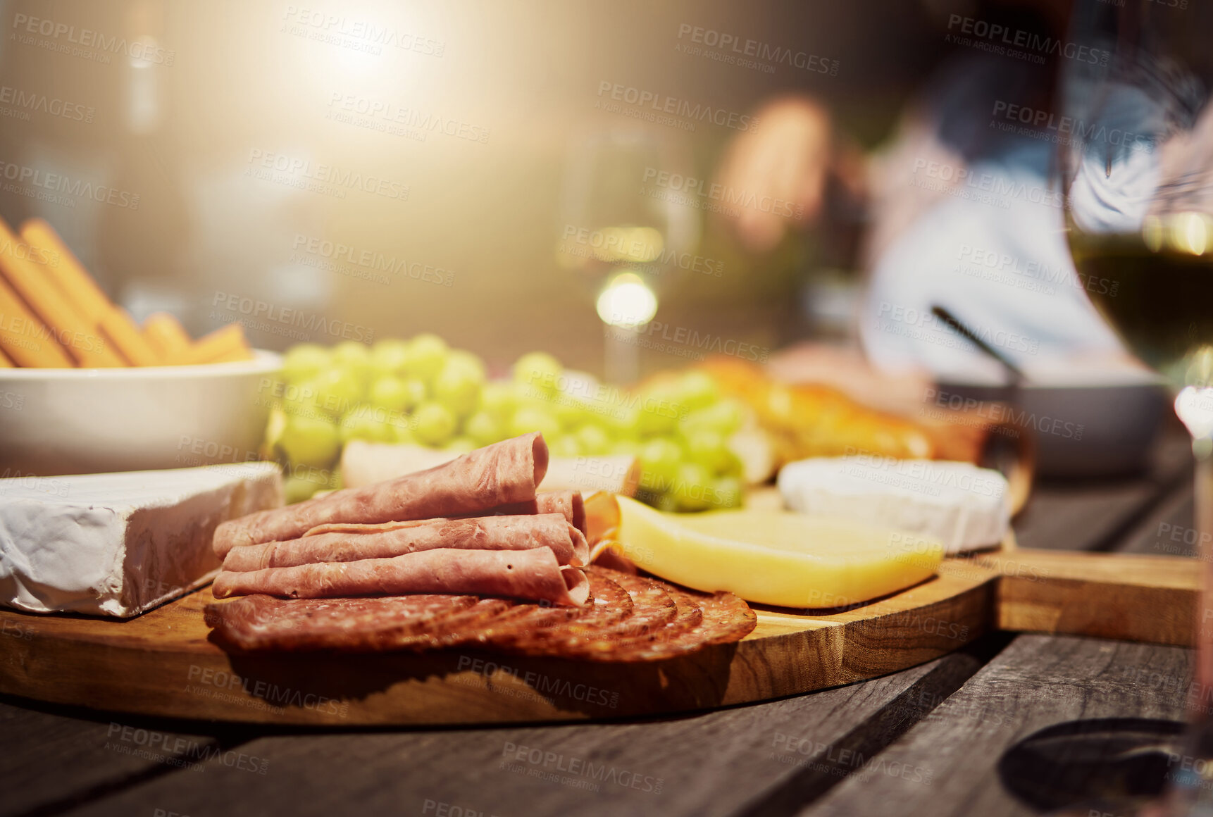 Buy stock photo Brunch, wine and cheese on snack board for picnic buffet, celebration and food in backyard. Bread, meat and fruit for charcuterie board at outdoor garden party for thanksgiving drinks with friends