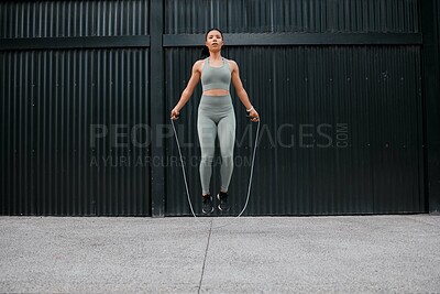 Buy stock photo Athlete, woman and jumping with rope outdoor for fitness, sports training and energy of health workout. Active, girl and leap with cardio performance, endurance exercise and competition practice