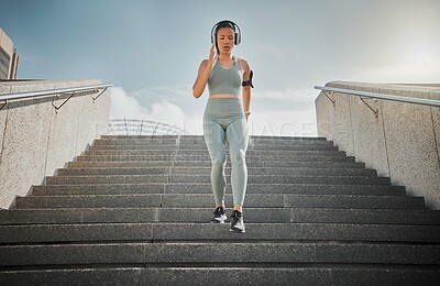 Buy stock photo Active, woman and running with headphones on steps for cardio training, listen to music and marathon practice. Athlete, girl and fitness exercise with endurance, sports workout and race performance