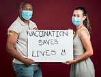 Covid vaccinated African american man and mixed race woman showing and holding poster. Two people wearing surgical face mask isolated on red studio background with copyspace. Promote corona vaccine