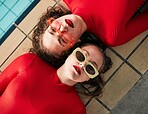 Women, sunglasses and urban fashion at a pool with gen z, hipster and style of girl friends with streetwear. Red clothing, cool and trendy glasses with young people on a floor with student model