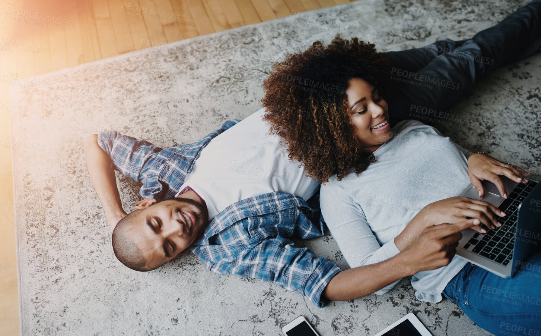 Buy stock photo Relax, floor and couple with laptop in living room for social media, communication or browsing internet. Lens flare, happy man and woman on carpet for typing, subscription or online shopping in home