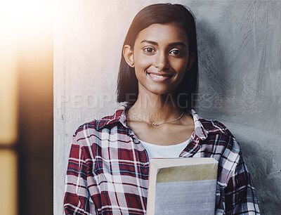 Buy stock photo Girl, university student and book in portrait by wall at business school, smile and education. Indian person, happy and studying for career in HR with research for industrial psychology at college