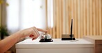 Hand, person and press bell at hotel reception as guest for help, customer service and hospitality. Closeup, female person and buzzer at front desk of resort for accommodation, booking or reservation