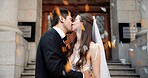 Couple, kiss and hug on wedding outdoor for celebration, unity success and marriage commitment. Young, people and confetti with promise of partnership, relationship love and romance ceremony at court