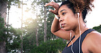 Girl, runner and earphones with sweat, outdoor or perspective with music, fatigue or fitness training in woods. Woman, reflection and streaming for exercise, workout and tired in forest in Costa Rica