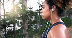 Woman, runner and earphones with sweat, nature or music for perspective, fatigue or fitness training in summer. Girl, reflection and streaming in forest for exercise, workout and tired in Costa Rica