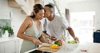 Buy stock photo Couple, kiss and cooking in kitchen for bonding, dinner and relationship together with vegetables. African people, smile and meal prep in home for love, support and brunch with food, diet and salad