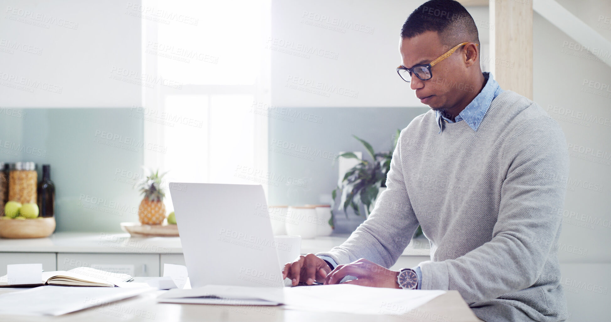 Buy stock photo Man, laptop and paperwork in kitchen for insurance review, mortgage documents and bills in home. Guy, computer and online accounting with asset management, tax registration and budget spreadsheet