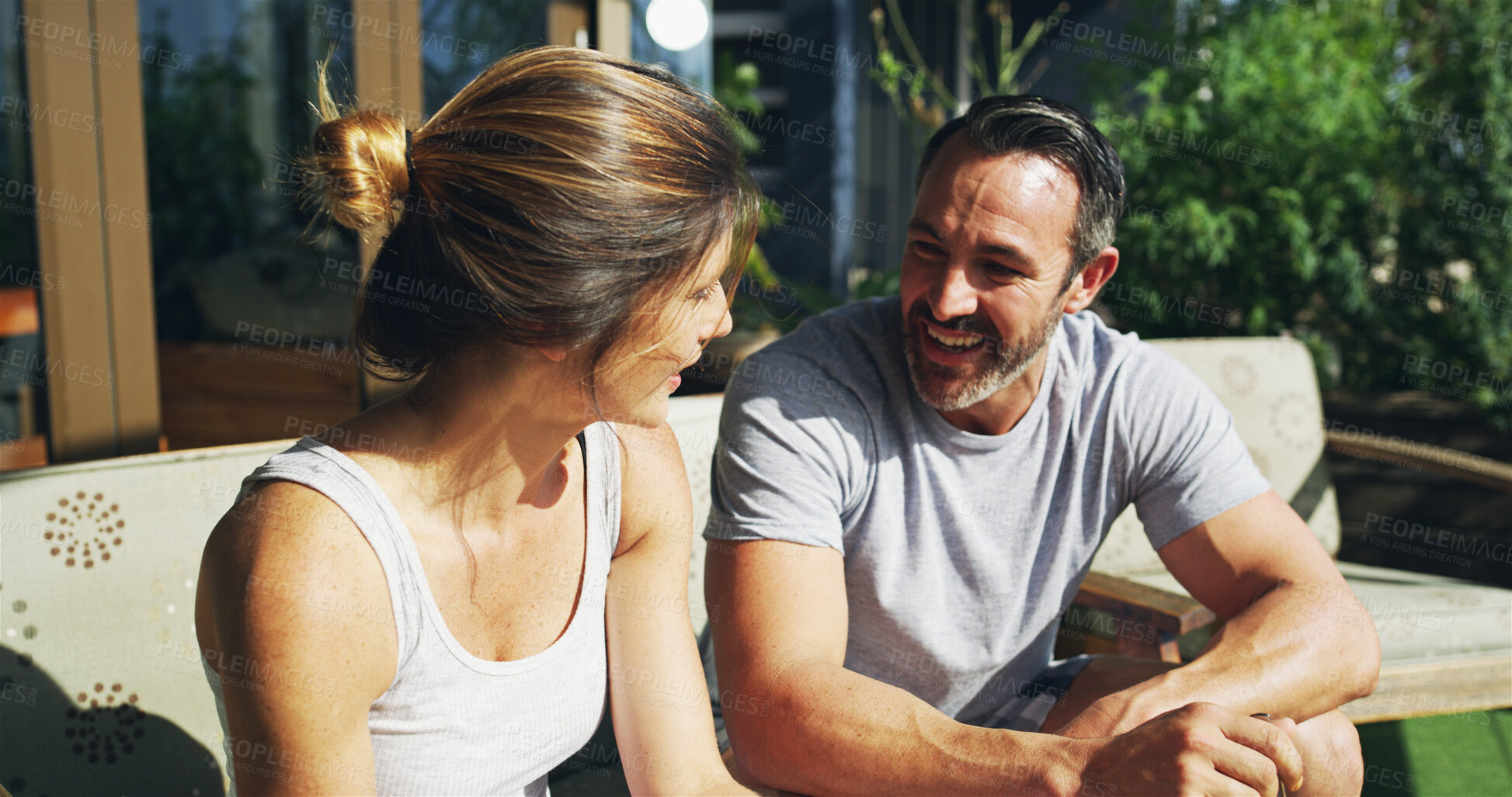 Buy stock photo Relax, happy couple and talking outdoor for love, care and story on sofa in backyard by house. Mature man, woman and conversation together for relationship, connection or communication with partner