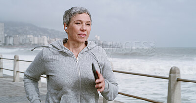 Buy stock photo Running, health and music with old woman at beach for fitness podcast, wellness and streaming. Athlete, training and workout with senior person and earphones for challenge, exercise and cardio 