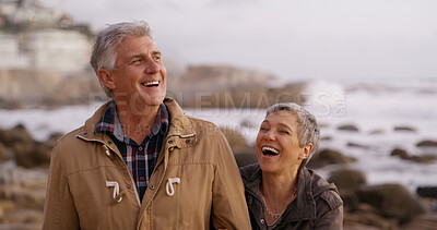 Buy stock photo Laughing, sunset and mature couple by ocean for bonding, relationship and love in nature. Conversation, marriage and happy man and woman by sea for romance, funny joke and relax together on weekend