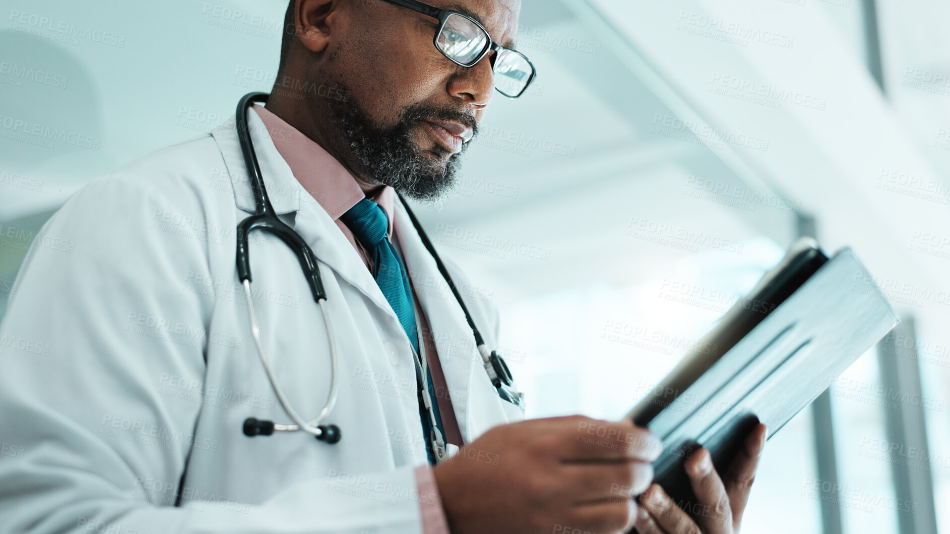 Buy stock photo Doctor, black man and tablet for healthcare in hospital with medical research, Telehealth and surgery schedule. Male surgeon, reading and digital for history report, patient information and diagnosis