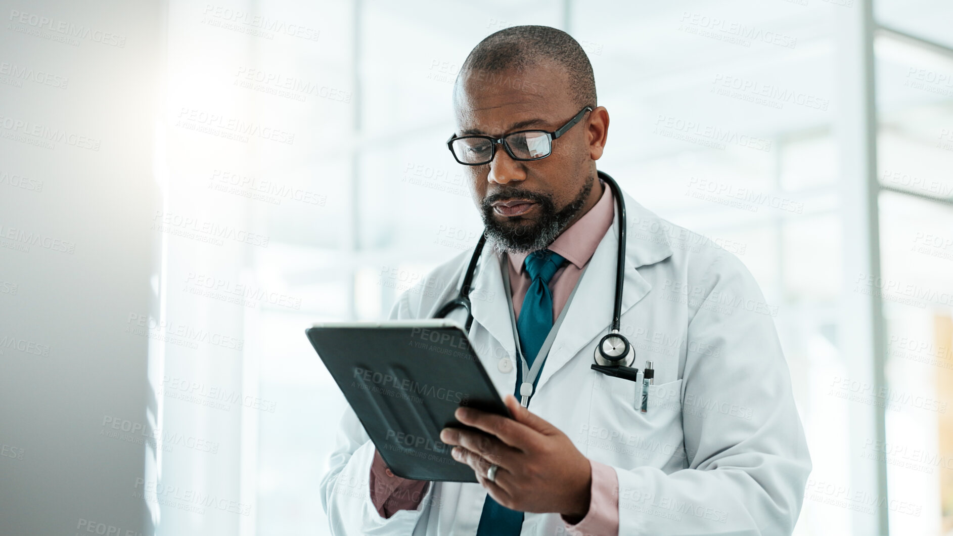 Buy stock photo Black man, surgeon and tablet for healthcare in hospital with medical research, Telehealth and surgery schedule. Male doctor, reading and digital for history report, patient information and diagnosis