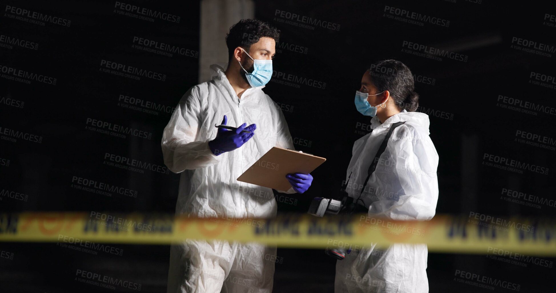 Buy stock photo Forensics team, discussion and crime scene investigation with clipboard, report or evidence at night. Investigators, man and woman with police outdoor for murder case, planning and clues for mystery