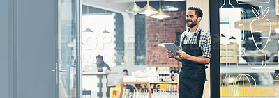 Buy stock photo Shot of a young man using a digital tablet in the store that he works at