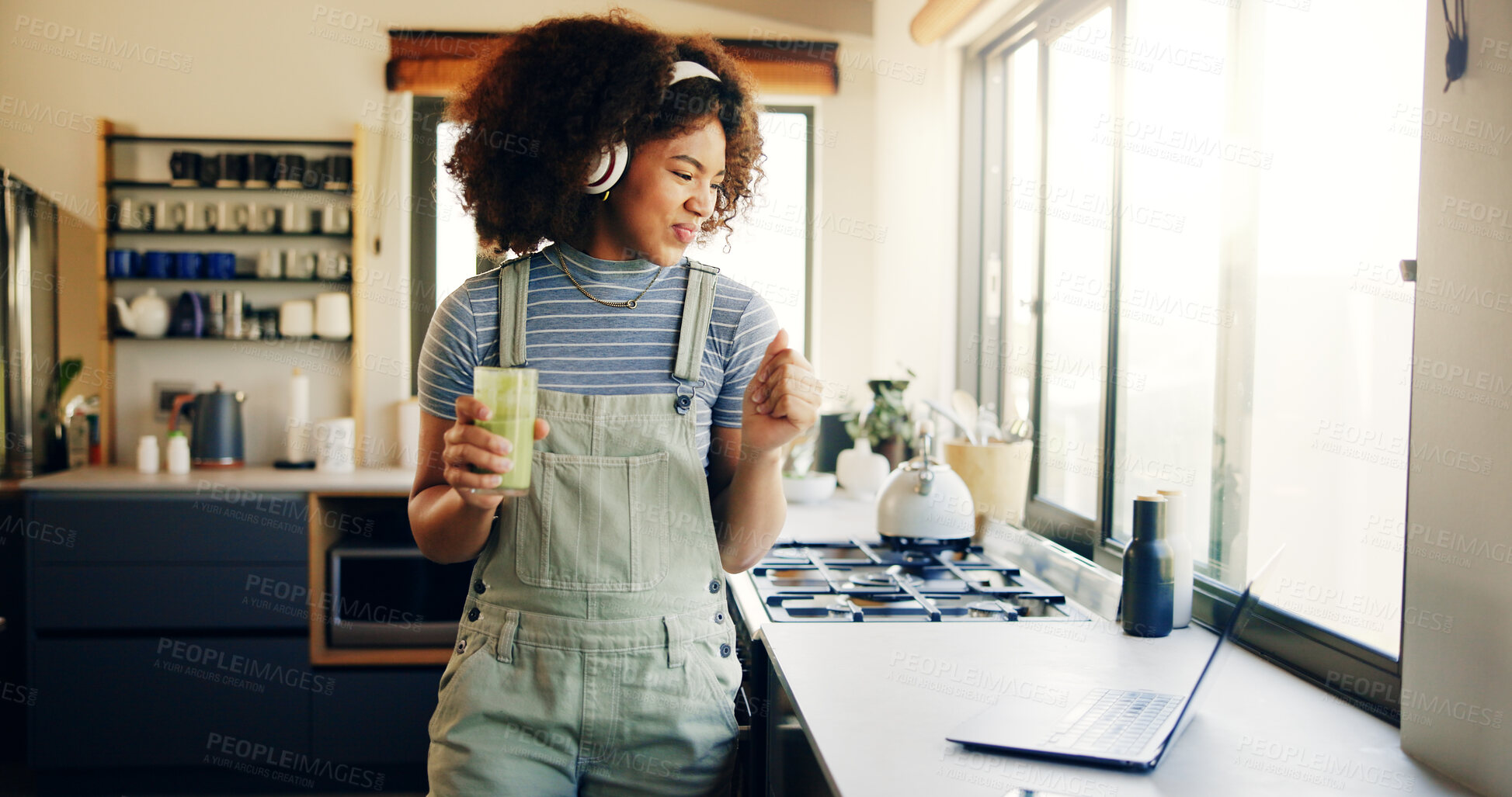 Buy stock photo Smoothie, headphones and laptop with woman in kitchen for cooking blog, detox recipe and green juice post. Streaming, morning and social media with person and dance at home for wellness and nutrition