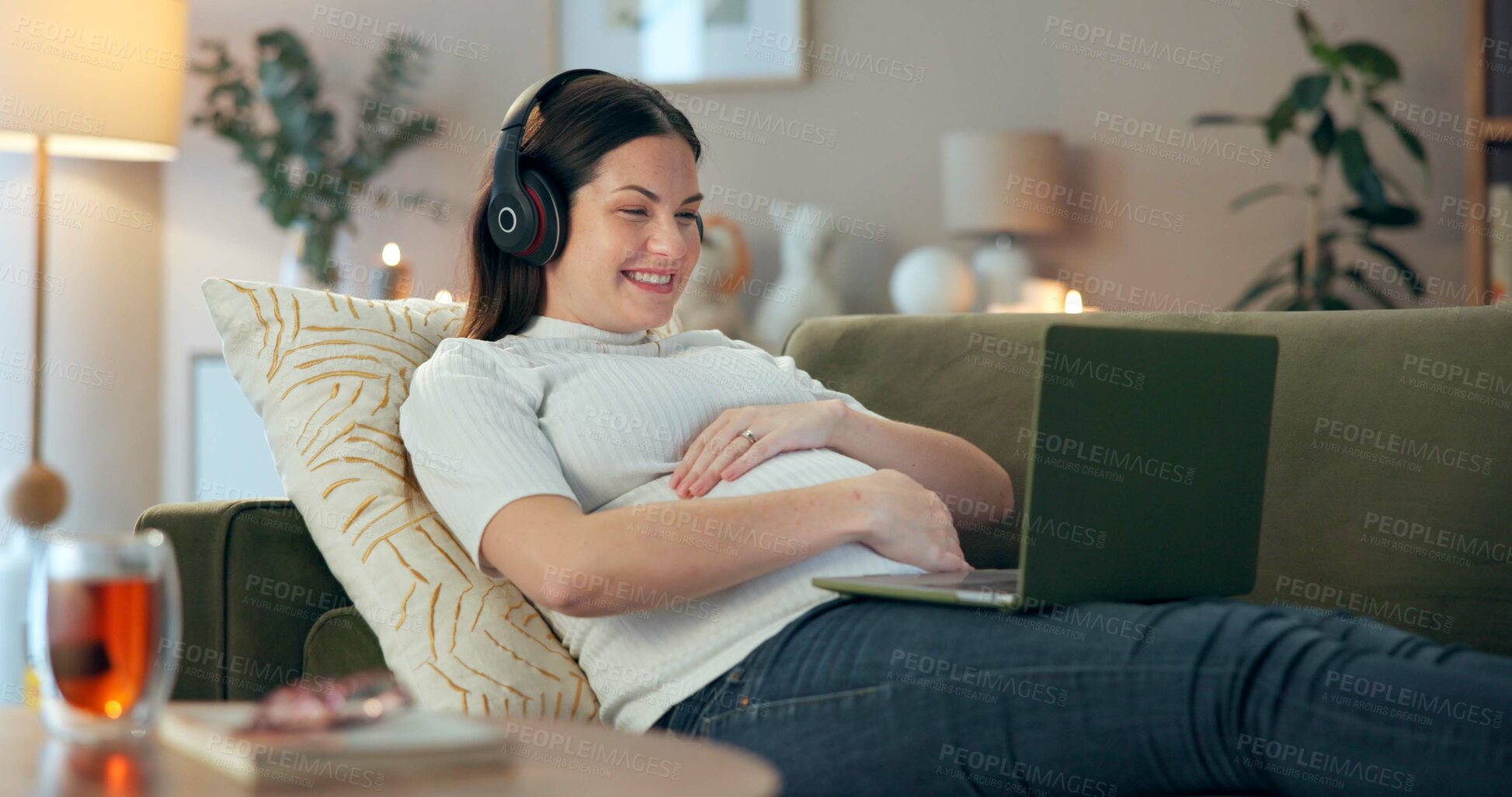 Buy stock photo Laptop, hand on stomach and pregnant woman with headphones, streaming and movies on home sofa. Pregnancy, research and mom with internet search, prenatal website or social media motherhood advice