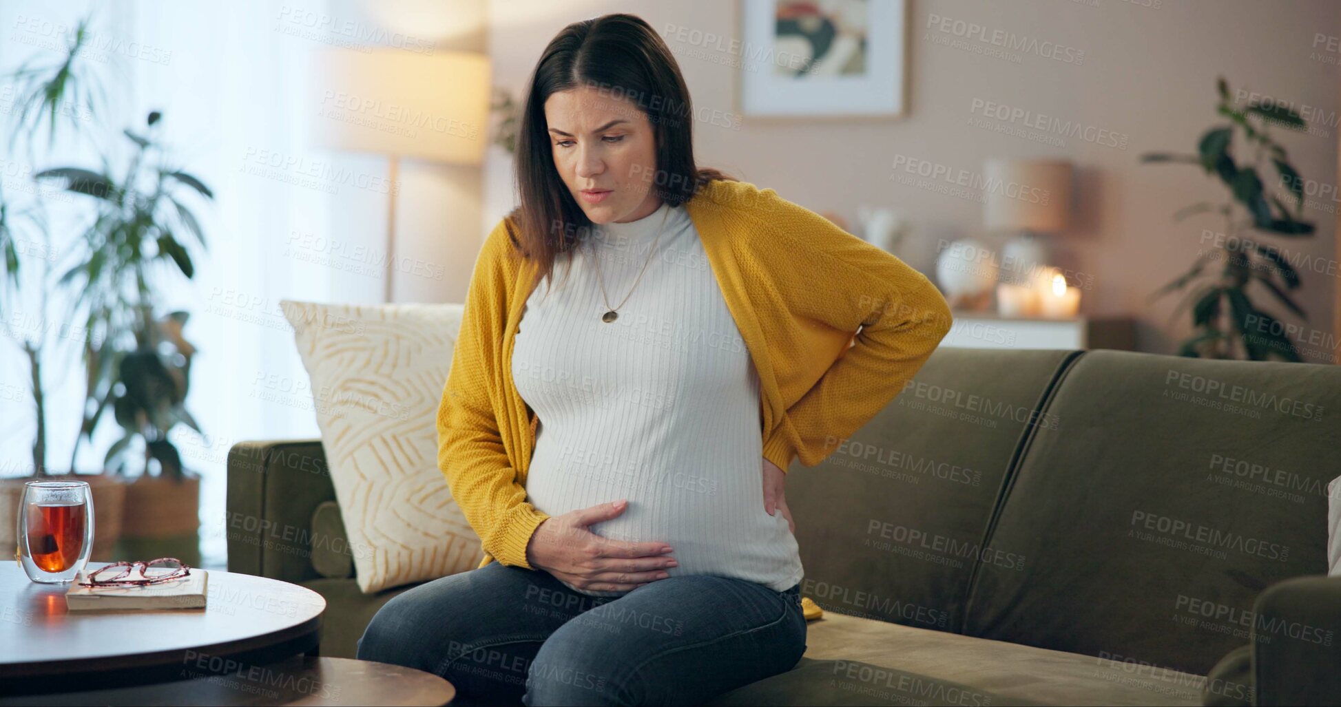 Buy stock photo Home, pregnant woman and back pain on sofa with stress, inflammation and joint tension from pregnancy. Living room, care and spine problem from muscle injury with breathing and anxiety from labor