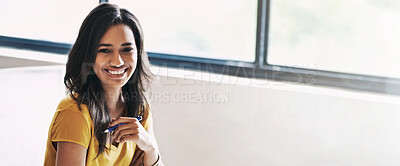 Buy stock photo Shot of a young designer sitting at her desk