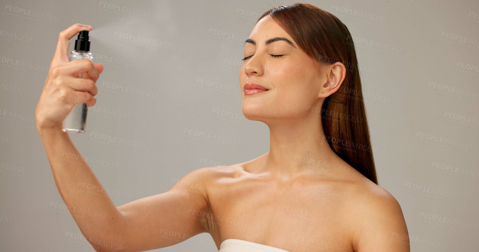 Buy stock photo Woman, studio and makeup with setting spray for beauty, glow and cosmetics on gray background. Female person, beautician and eyes closed with face mist for application, foundation and blending