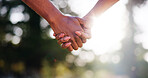 Couple, forest or holding hands with sunshine for support, hope or bonding together in nature. Closeup, man or woman with touch, connection or love for commitment, holiday or outdoor weekend in woods