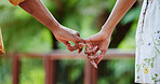 Holding hands, couple and outdoor with pinky promise for commitment, loyalty and trust together. Park, hope and people on vacation with partner on date with relationship, bonding and care with travel
